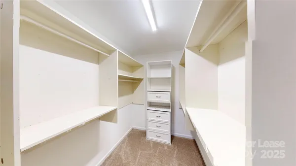 a view of walk in closet with empty racks