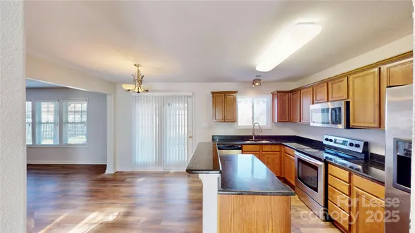 a kitchen with stainless steel appliances granite countertop a sink counter space and wooden floor