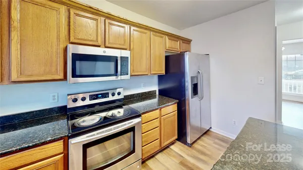a kitchen with stainless steel appliances granite countertop a stove microwave and refrigerator