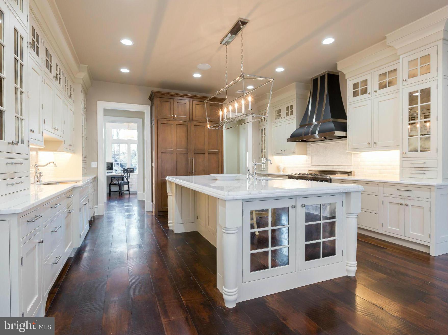 821 Turkey Run Road McLean, VA 22101 - Photo 12 of 30 a large white kitchen with stainless steel appliances and wooden floors