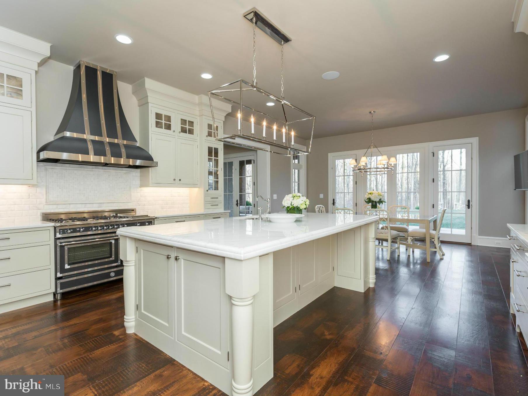 821 Turkey Run Road McLean, VA 22101 - Photo 13 of 30 a kitchen with stainless steel appliances a dining table chairs stove and sink