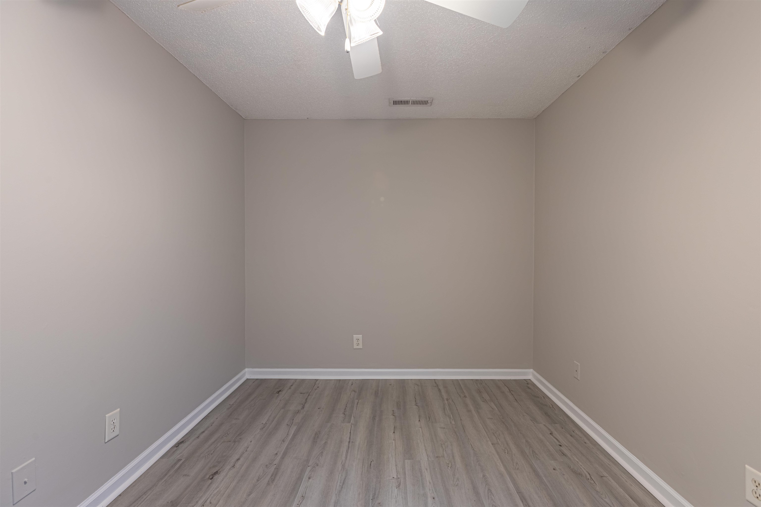 1001 Mistletoe Court Myrtle Beach, SC 29579 - Photo 20 of 28 Unfurnished bedroom with wood finished floors, a ceiling fan, a closet, and a textured ceiling