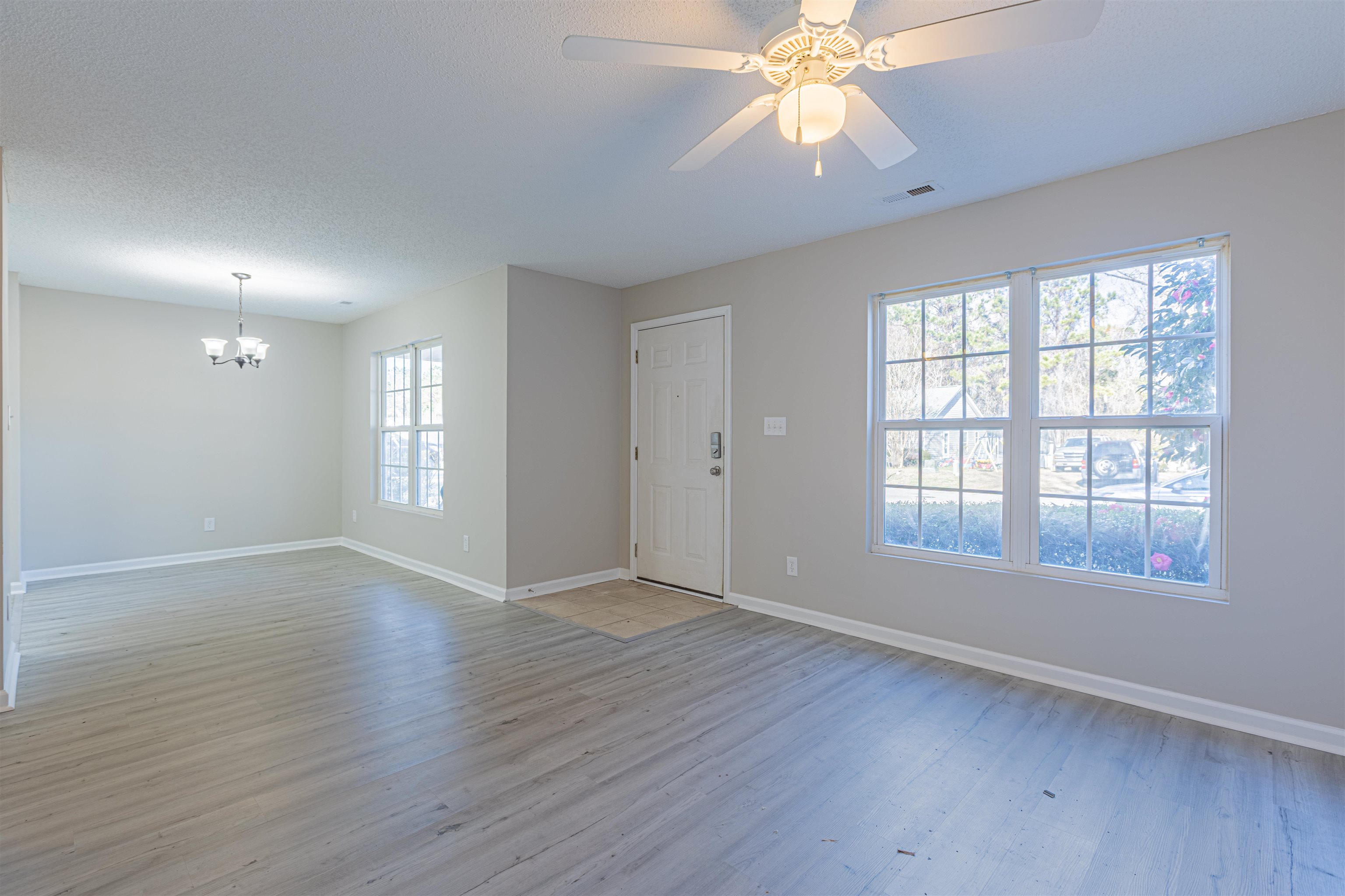 1001 Mistletoe Court Myrtle Beach, SC 29579 - Photo 4 of 28 Entryway with light wood-style flooring, a ceiling fan, a chandelier, and a textured ceiling