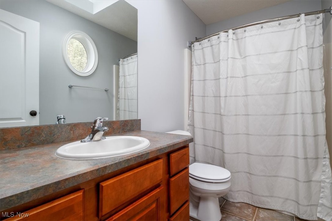 4679 Paxton Road Akron, OH 44321 - Photo 37 of 46 Bedroom 2's private bath that has maple cabinet and tub surround, and tiled floors