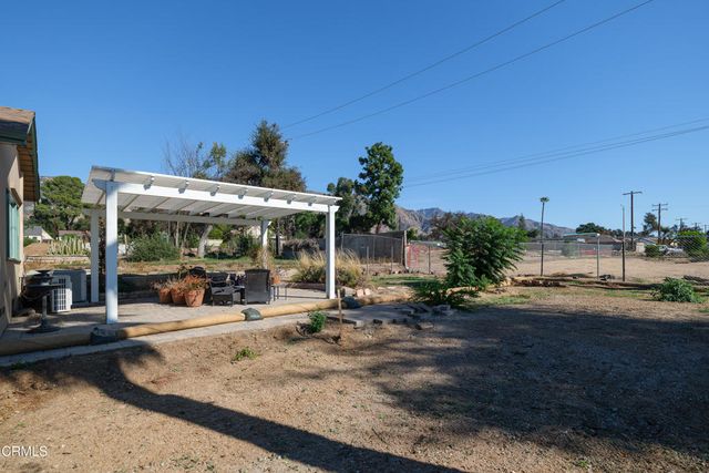 a view of a patio with table and chairs and a barbeque
