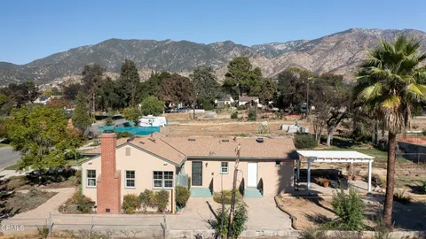 a view of a house with a yard and tree s