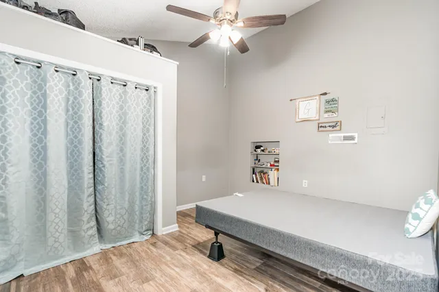 an empty room with windows and ceiling fan