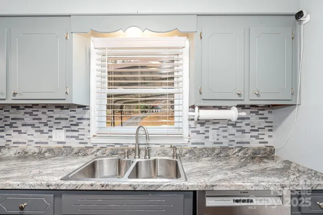a kitchen with granite countertop a sink and a window