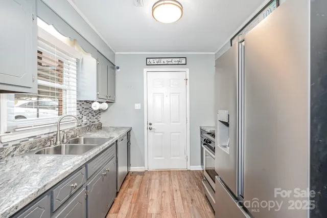a kitchen with a sink and wooden floor