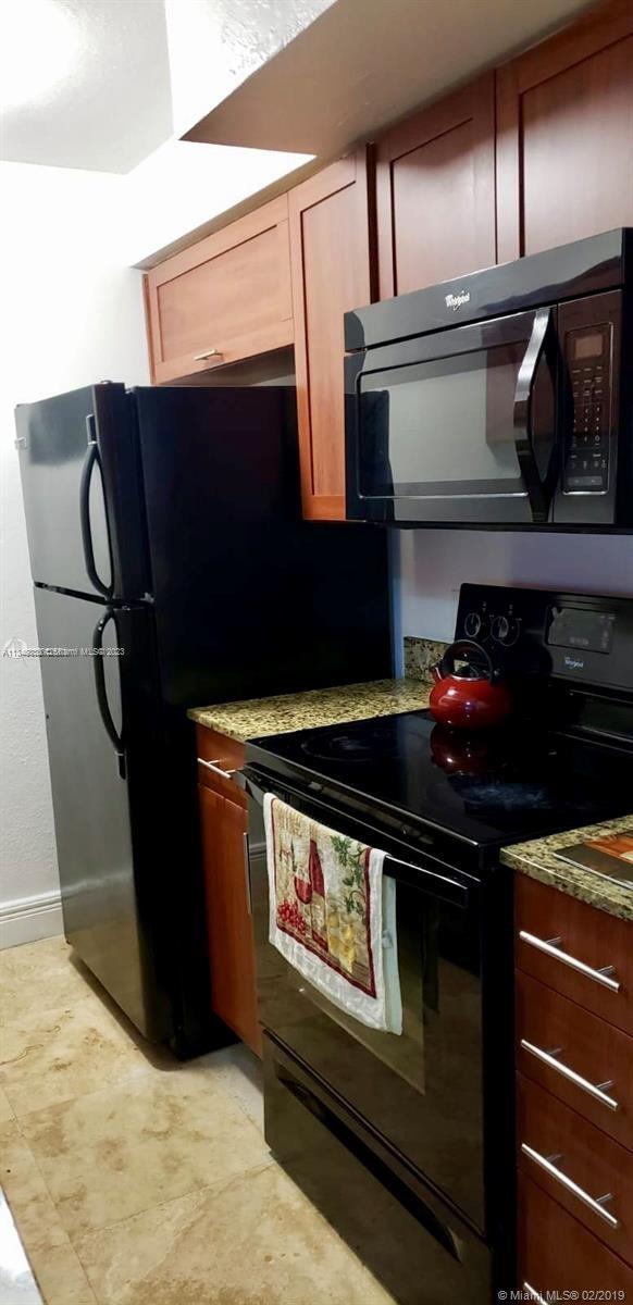 Normandy Isle Miami Beach, FL 33141 - Photo 10 of 12 a kitchen with stainless steel appliances granite countertop a stove and a microwave