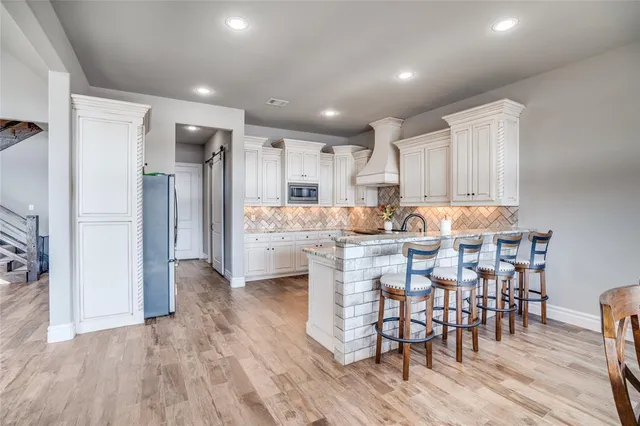 a kitchen with stainless steel appliances kitchen island granite countertop a refrigerator and a stove top oven