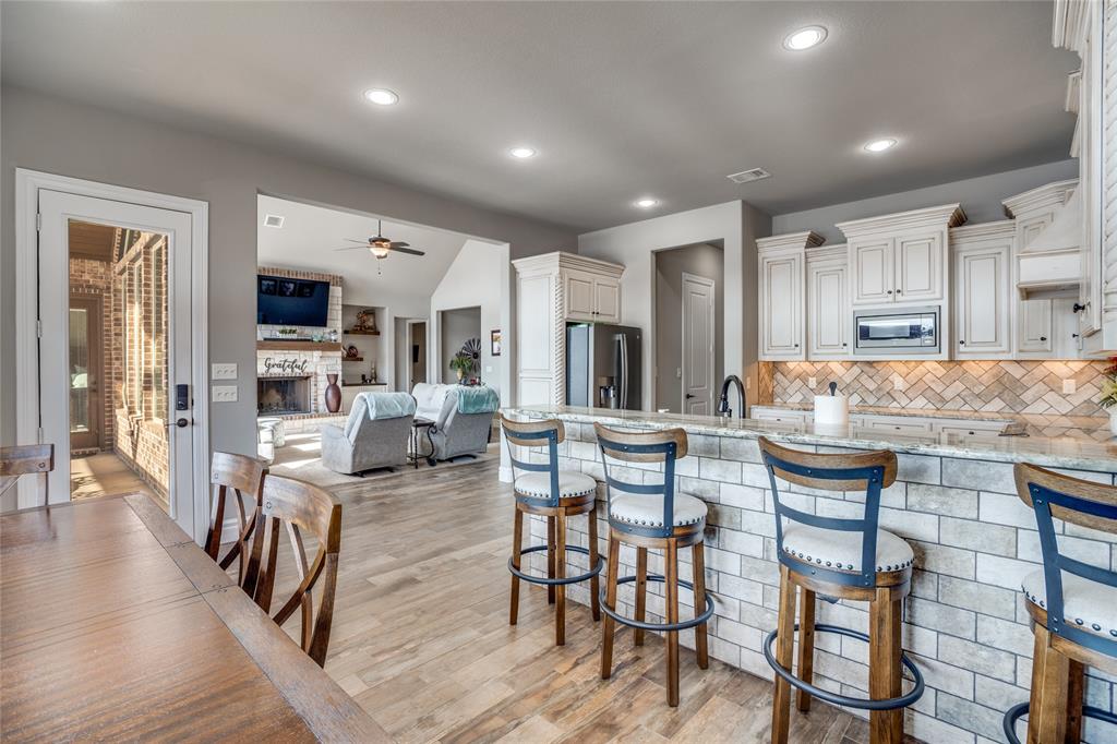 181 Ridgeline Drive Chico, TX 76431 - Photo 12 of 39 a kitchen with stainless steel appliances granite countertop dining table chairs refrigerator and microwave