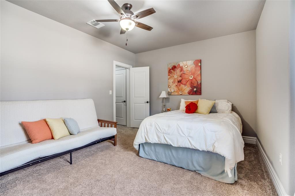 181 Ridgeline Drive Chico, TX 76431 - Photo 23 of 39 a bedroom with a large bed and a chandelier