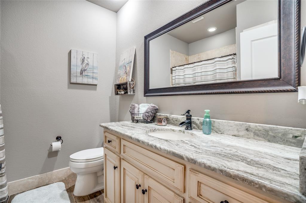 181 Ridgeline Drive Chico, TX 76431 - Photo 24 of 39 a bathroom with a granite countertop toilet sink and mirror