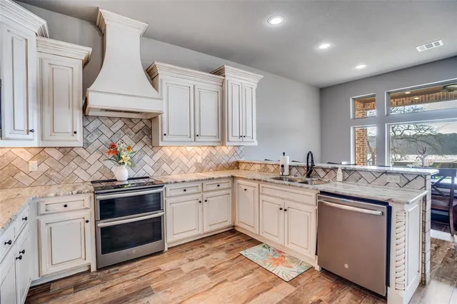 a kitchen with granite countertop white cabinets and white appliances