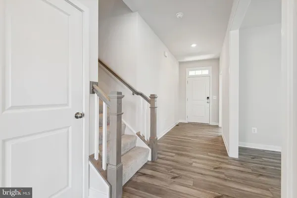 a view of a hallway with wooden floor and staircase