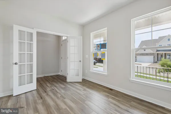 an empty room with wooden floor and windows