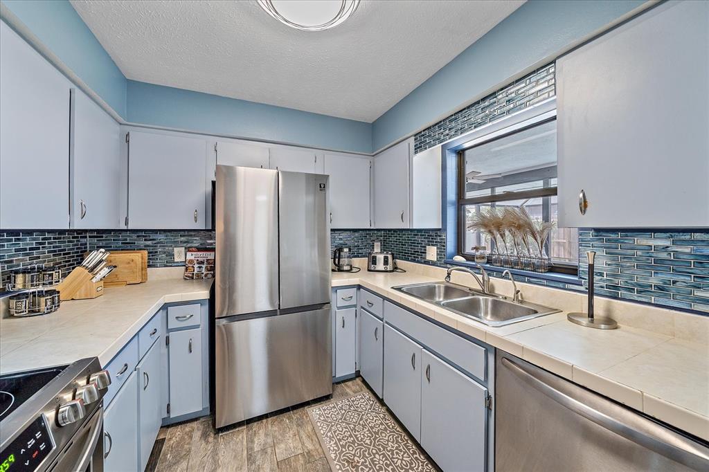 108 Stanford Road Venice, FL 34293 - Photo 11 of 28 a kitchen with a sink a refrigerator and cabinets