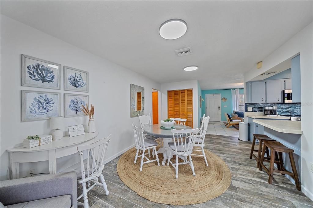 108 Stanford Road Venice, FL 34293 - Photo 13 of 28 a view of a dining room with furniture and wooden floor