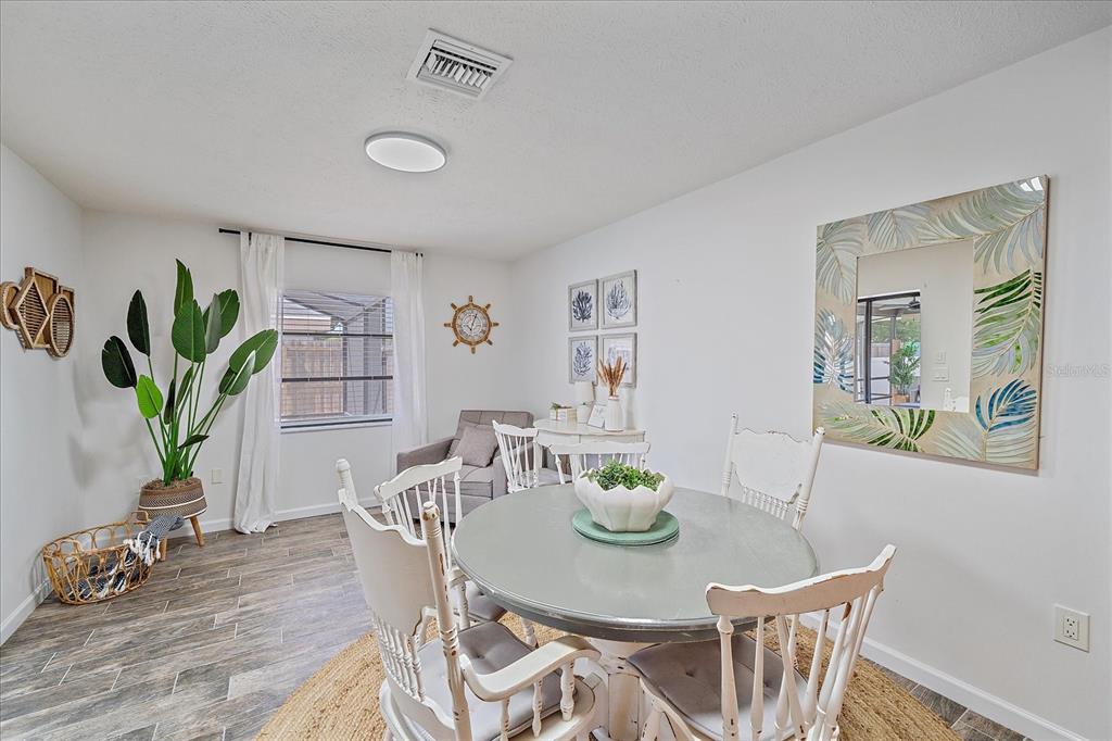 108 Stanford Road Venice, FL 34293 - Photo 14 of 28 a view of a dining room with furniture window and wooden floor