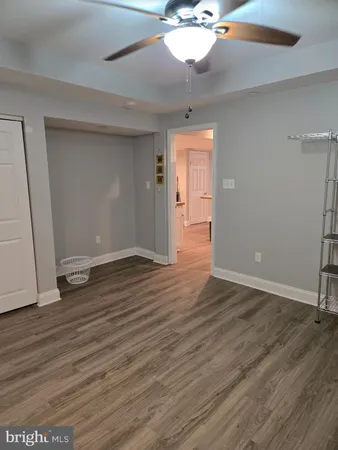 an empty room with wooden floor and chandelier fan