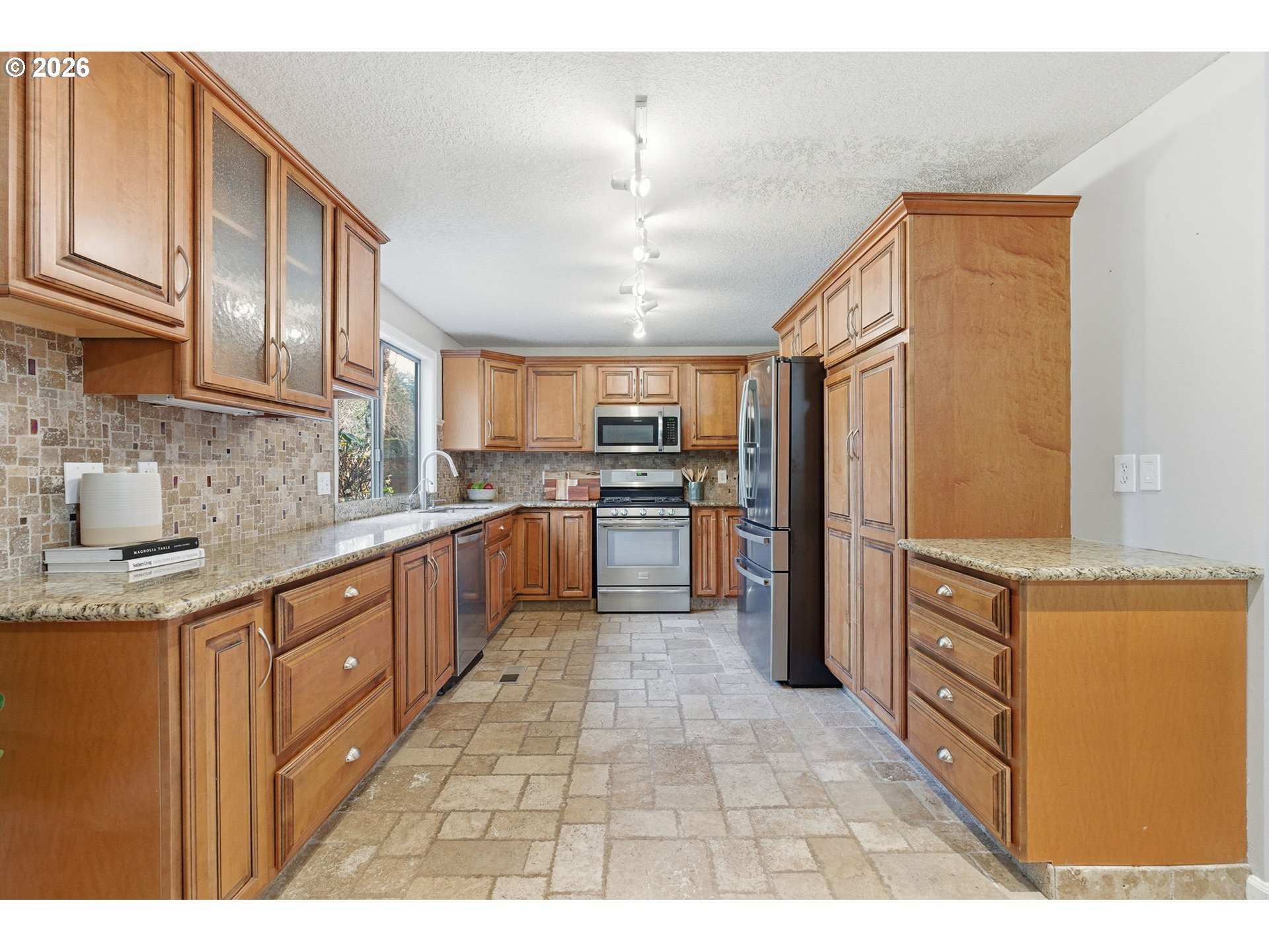 5585 Northwest Peregrine Place Portland, OR 97229 - Photo 13 of 47 a large kitchen with stainless steel appliances granite countertop a stove a sink dishwasher and a refrigerator
