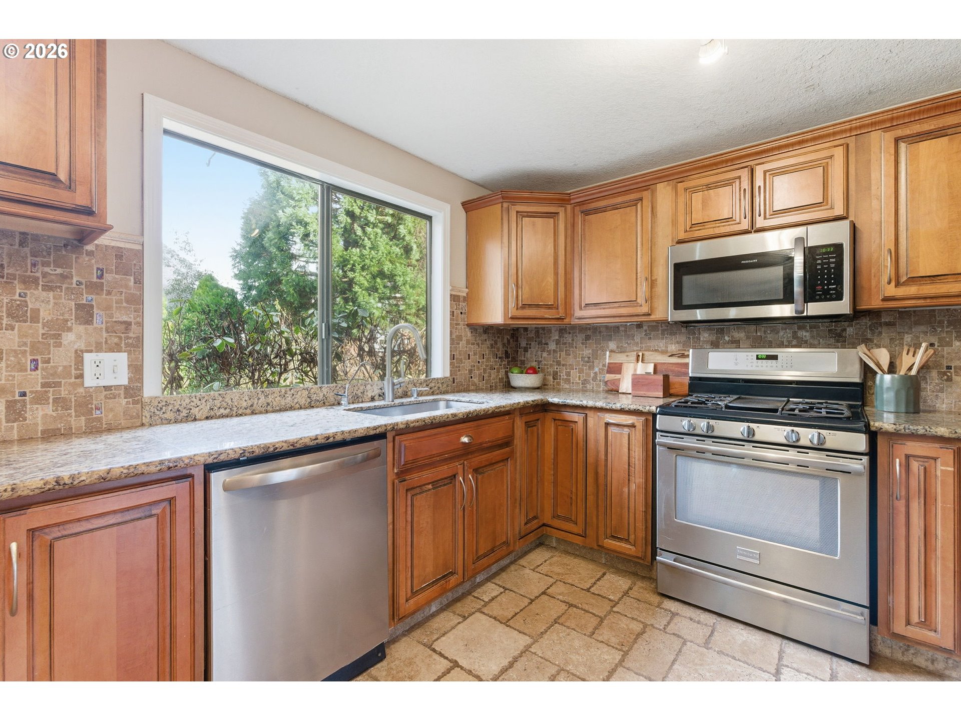 5585 Northwest Peregrine Place Portland, OR 97229 - Photo 16 of 47 a kitchen with stainless steel appliances granite countertop a stove a sink and a microwave