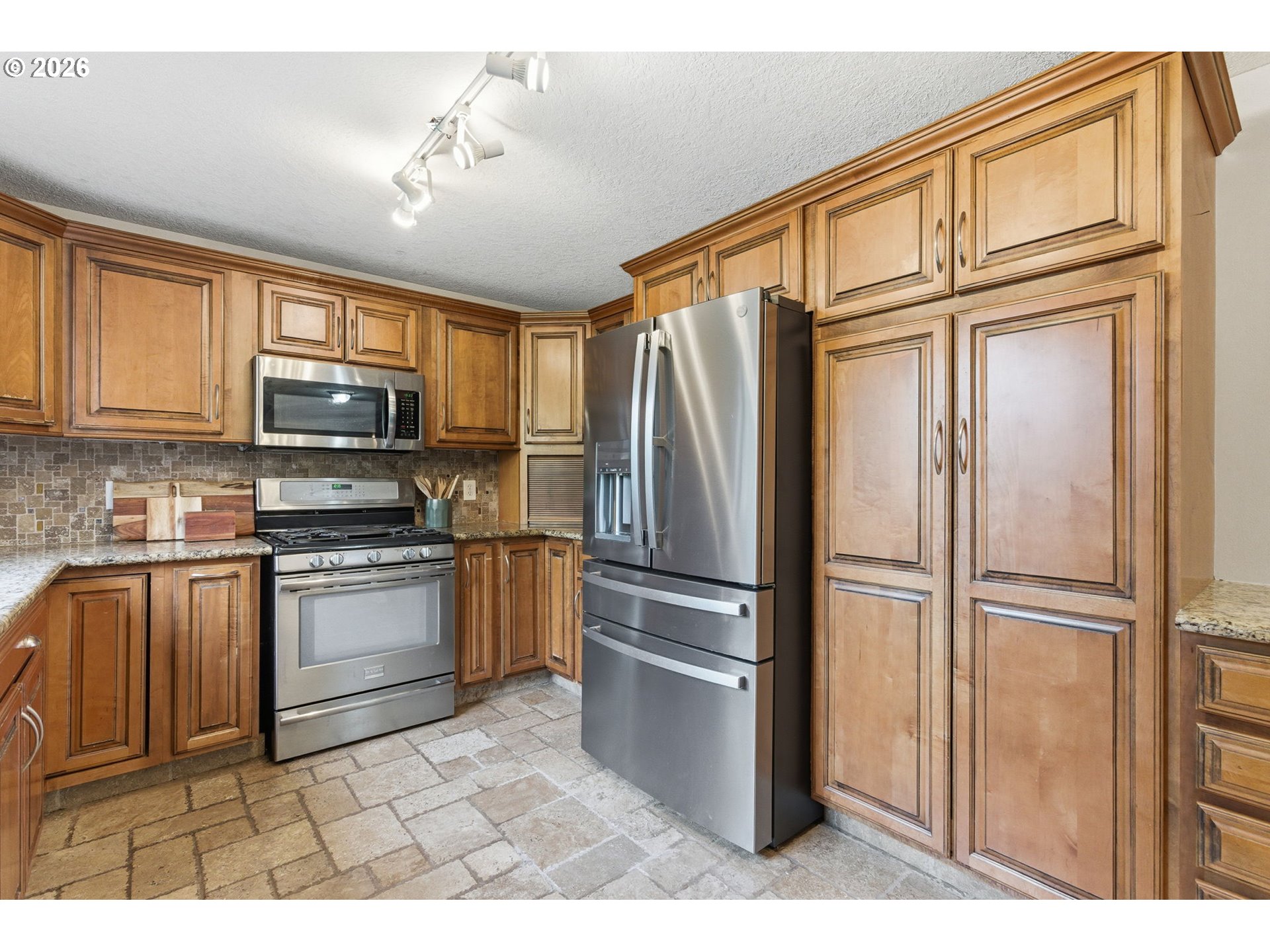 5585 Northwest Peregrine Place Portland, OR 97229 - Photo 17 of 47 a kitchen with granite countertop a refrigerator stove and microwave