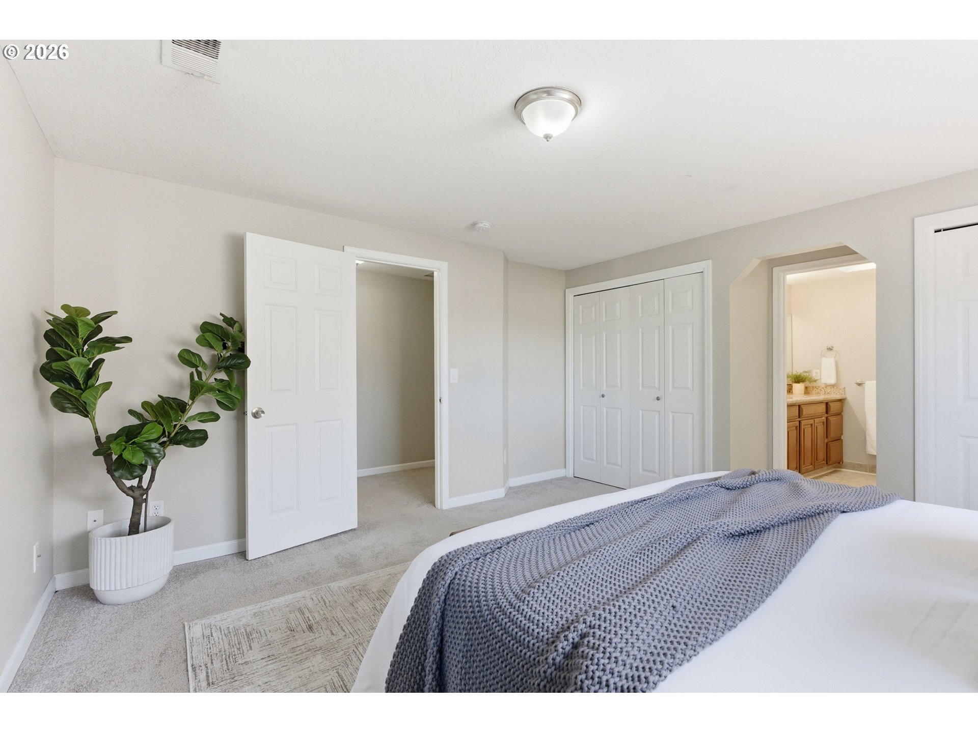 5585 Northwest Peregrine Place Portland, OR 97229 - Photo 30 of 47 a bedroom with a bed and a potted plant