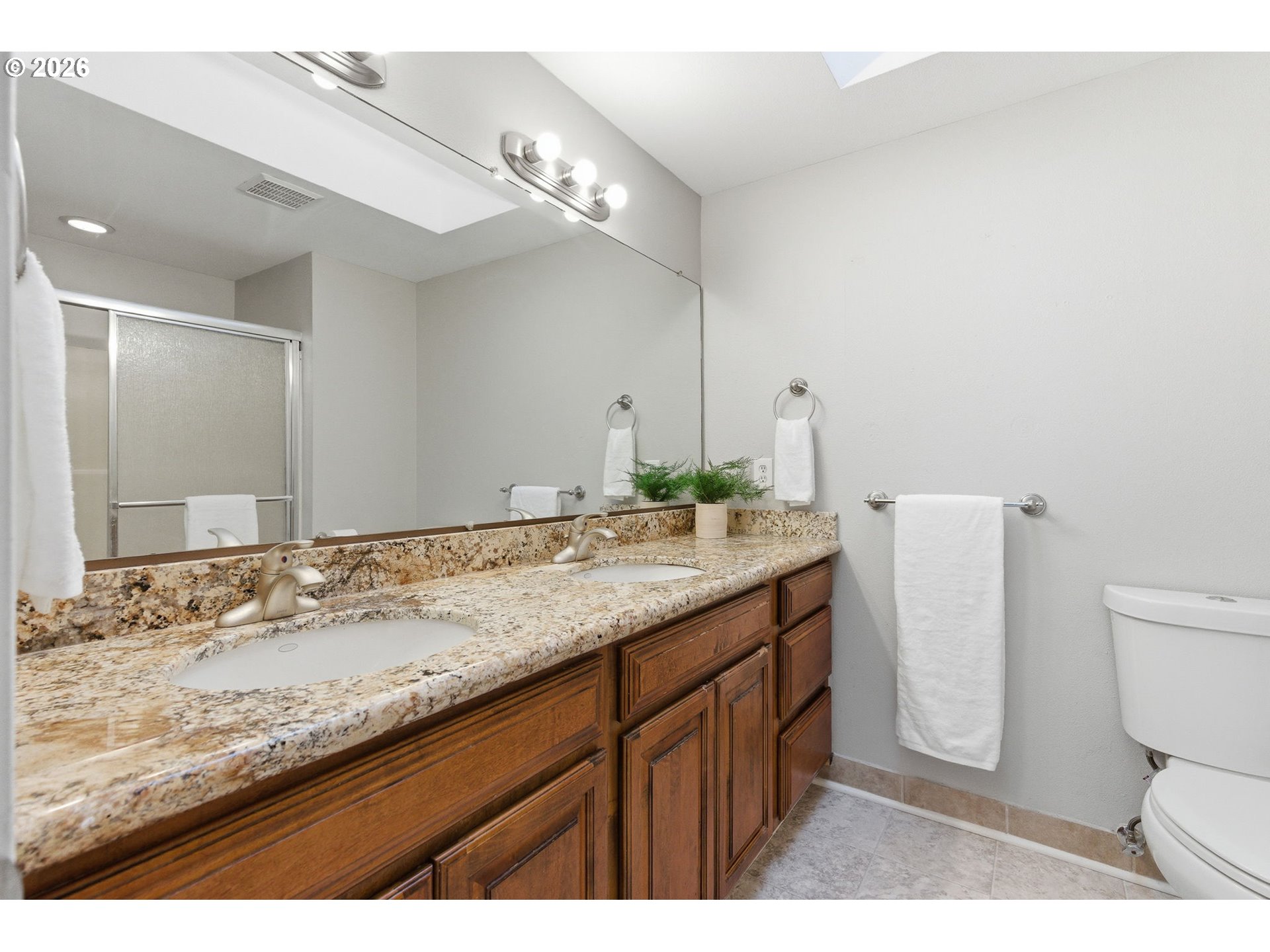 5585 Northwest Peregrine Place Portland, OR 97229 - Photo 31 of 47 a bathroom with a granite countertop sink a toilet and a mirror