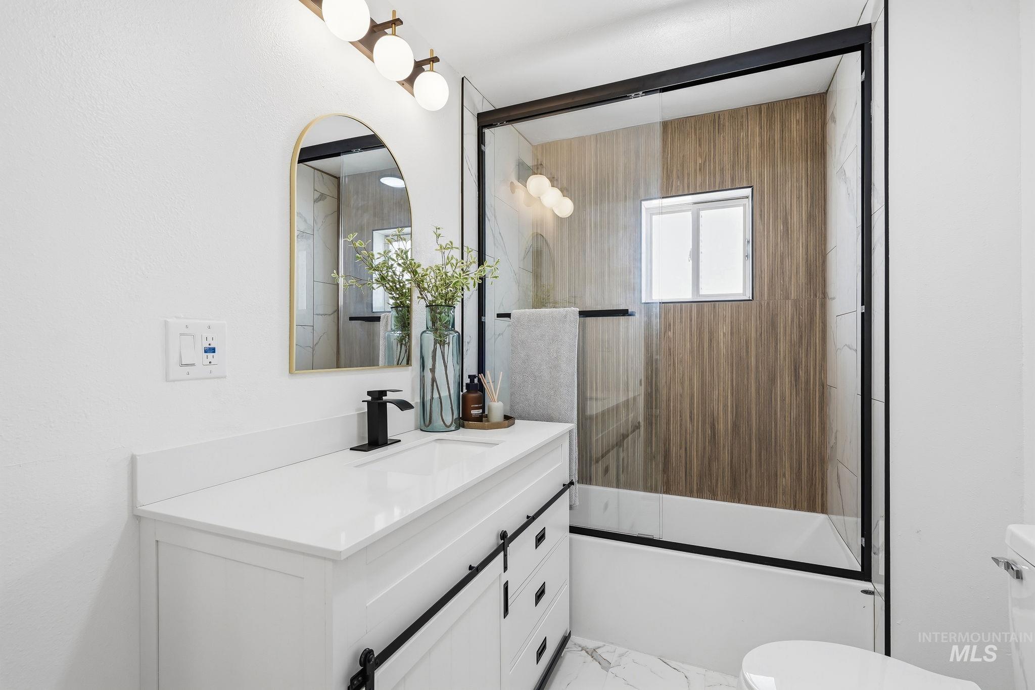 2152 Artesian Road Eagle, ID 83616 - Photo 29 of 50 Modern bathroom featuring a white vanity with barn door style hardware, a white countertop, and a black faucet