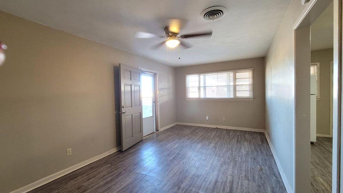 4429 31st Street Lubbock, TX 79410 - Photo 3 of 12 an empty room with wooden floor and windows