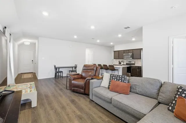 a living room with furniture and a view of kitchen