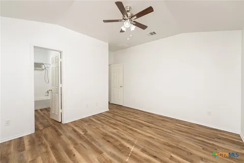 a view of a big room with wooden floor and a ceiling fan