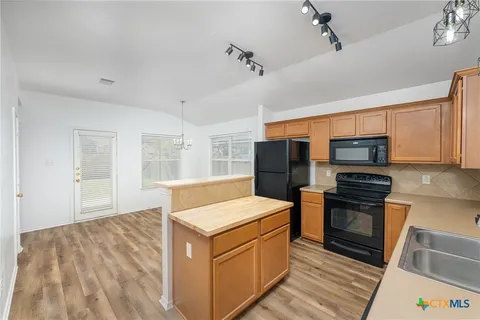 a kitchen with stainless steel appliances granite countertop a stove and a refrigerator