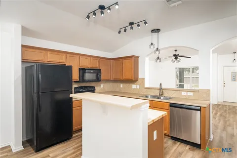 a kitchen with a sink refrigerator and microwave