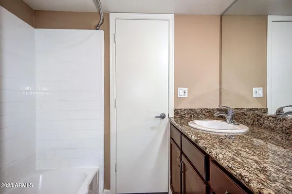 a bathroom with a granite countertop sink and a mirror