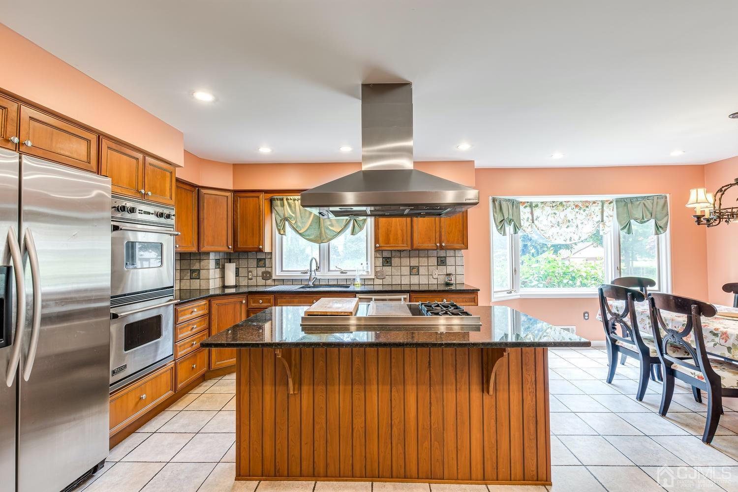 355 New Dover Road Colonia, NJ 07067 - Photo 14 of 45 a kitchen with stainless steel appliances granite countertop a stove top oven a sink and a refrigerator
