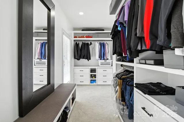 a view of walk in closet with clothes and shoes