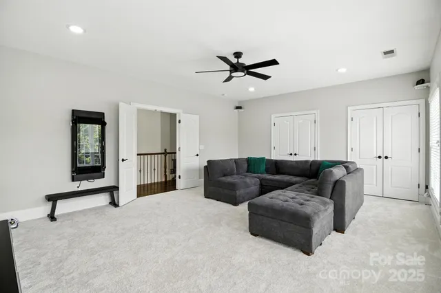 a living room with furniture and a ceiling fan