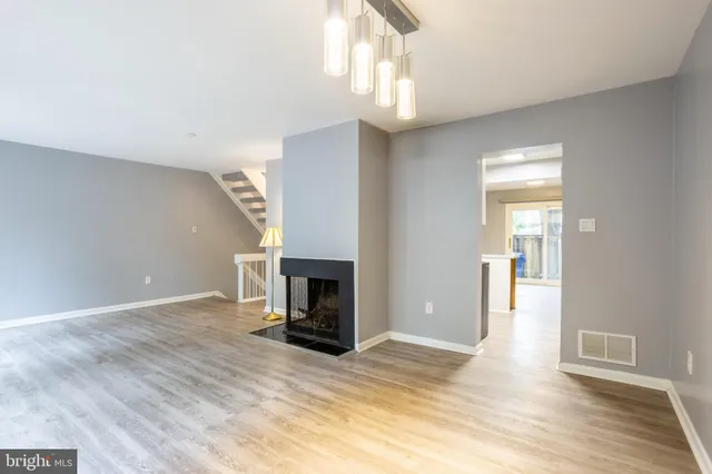 a view of empty room with wooden floor and fireplace