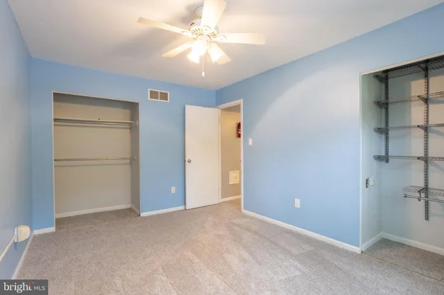 an empty room with closet and windows
