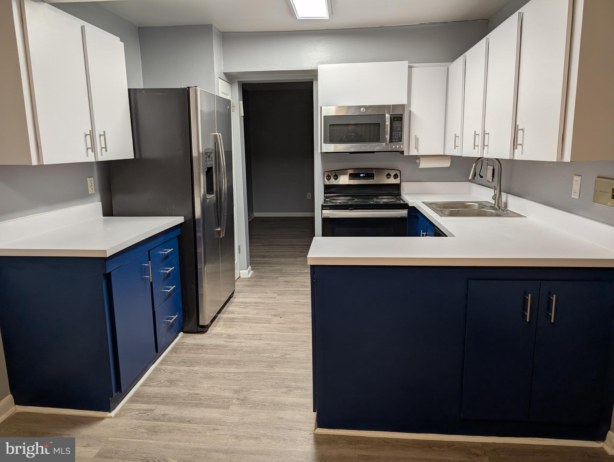 2835 Baneberry Court Baltimore, MD 21209 - Photo 7 of 42 a kitchen with a sink a microwave a refrigerator and cabinets