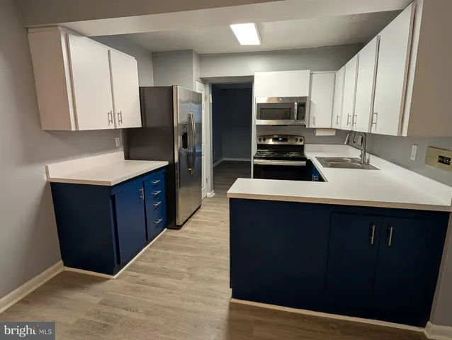 a kitchen with a sink a stove a refrigerator and cabinets
