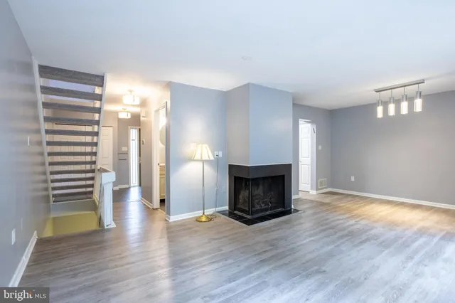 a view of empty room with wooden floor and fireplace