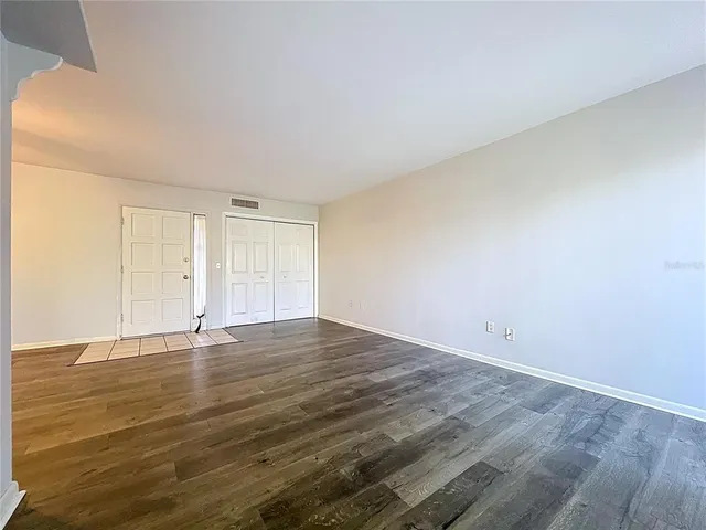 a view of an empty room with wooden floor