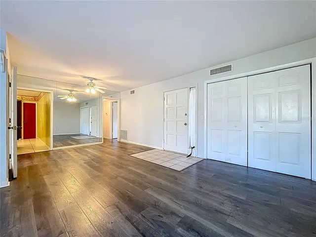 a view of a room with wooden floor and large window