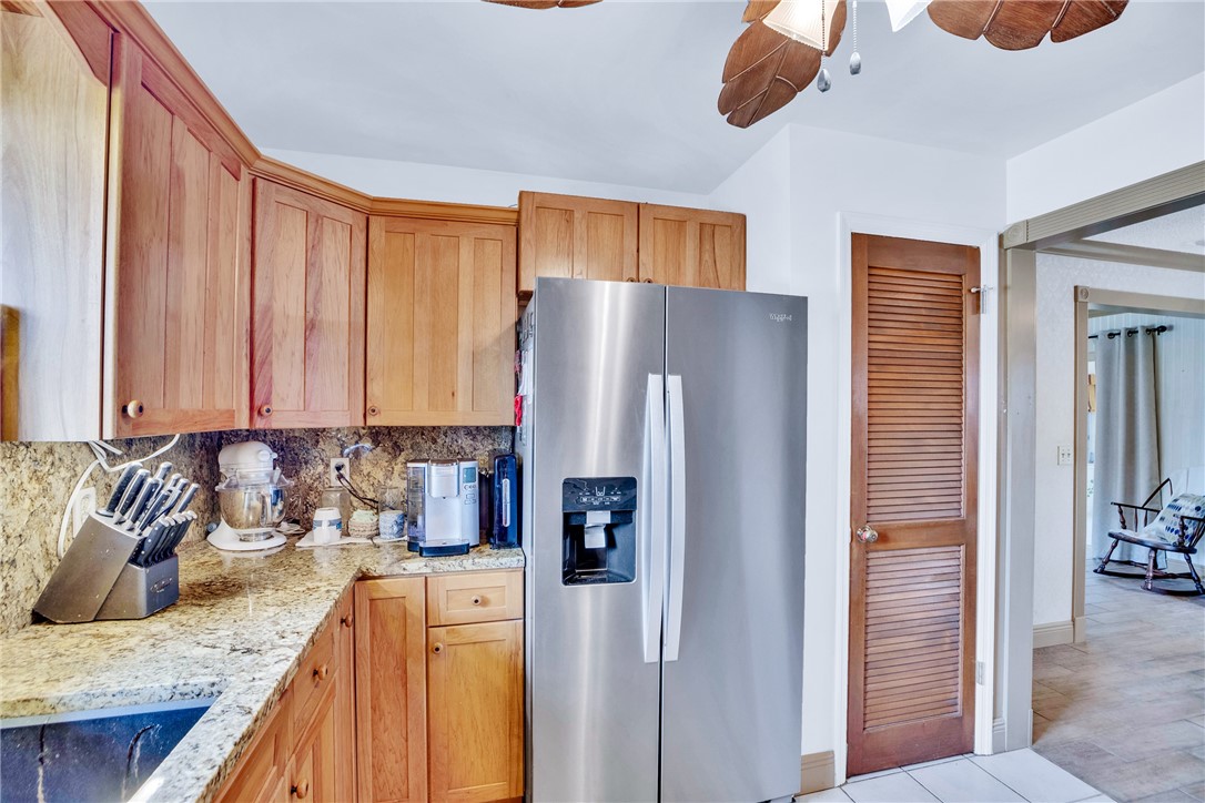 7666 134th Street Sebastian, FL 32958 - Photo 24 of 35 a kitchen with stainless steel appliances granite countertop a refrigerator and a stove top oven