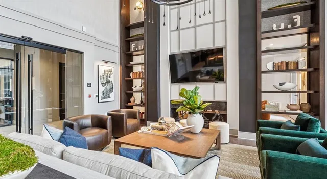 a living room with furniture a flat screen tv and a floor to ceiling window