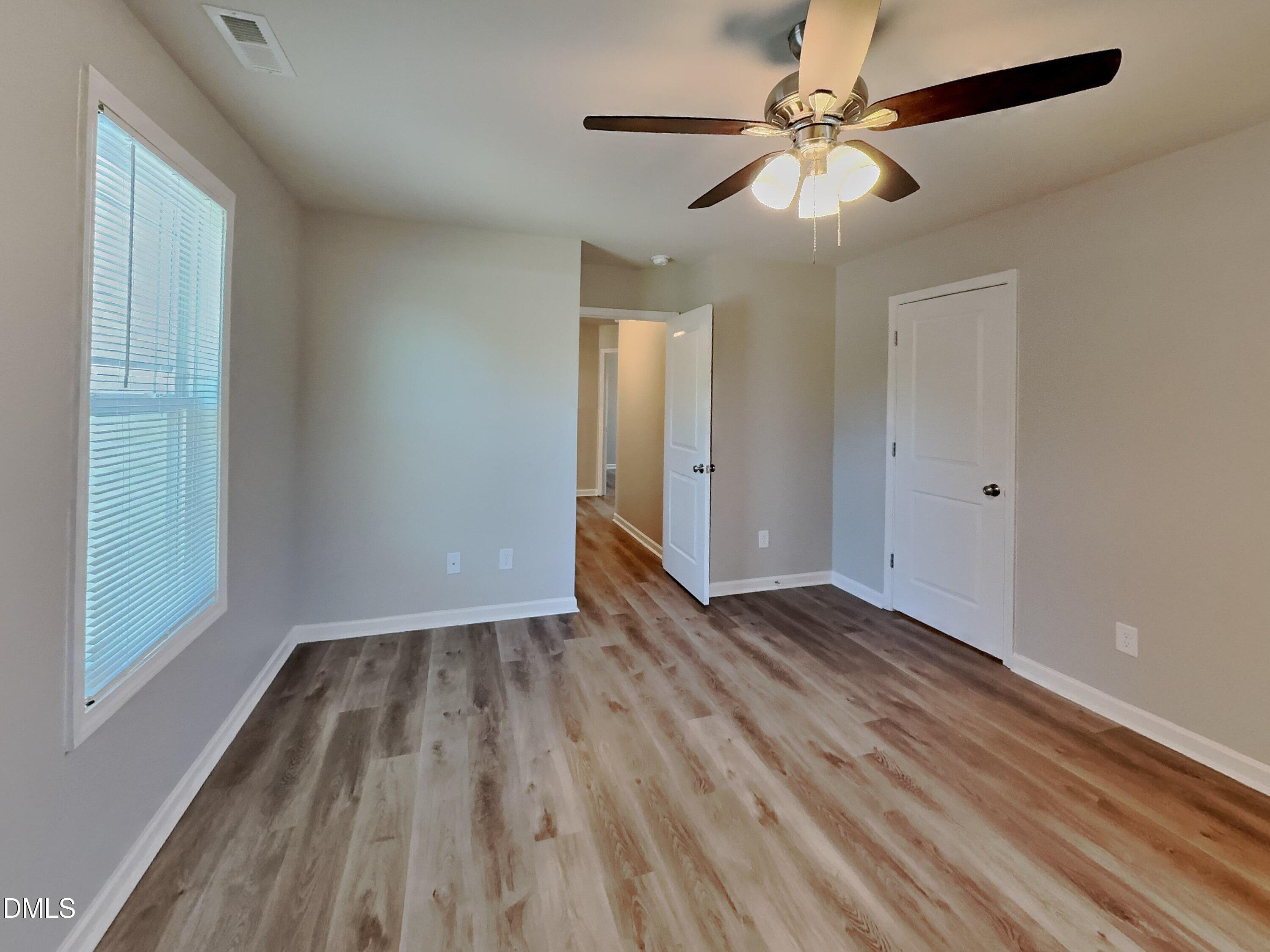 123 Willow Ridge Circle Willow Spring, NC 27592 - Photo 7 of 15 a view of an empty room with wooden floor and a window
